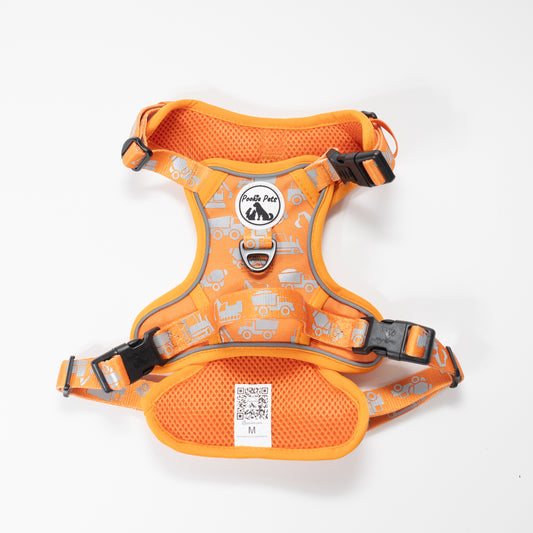 An orange dog harness with a pattern of trucks and a neoprene padding layer, featuring adjustable straps and a central D-ring.